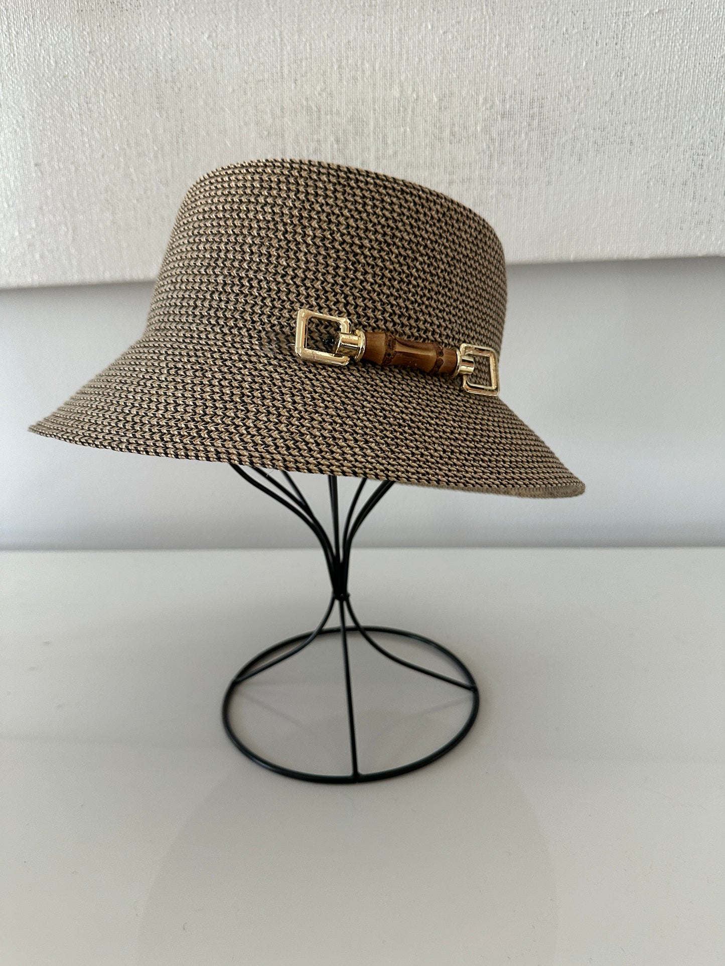 Brown woven bucket hat with gold buckle on a white background