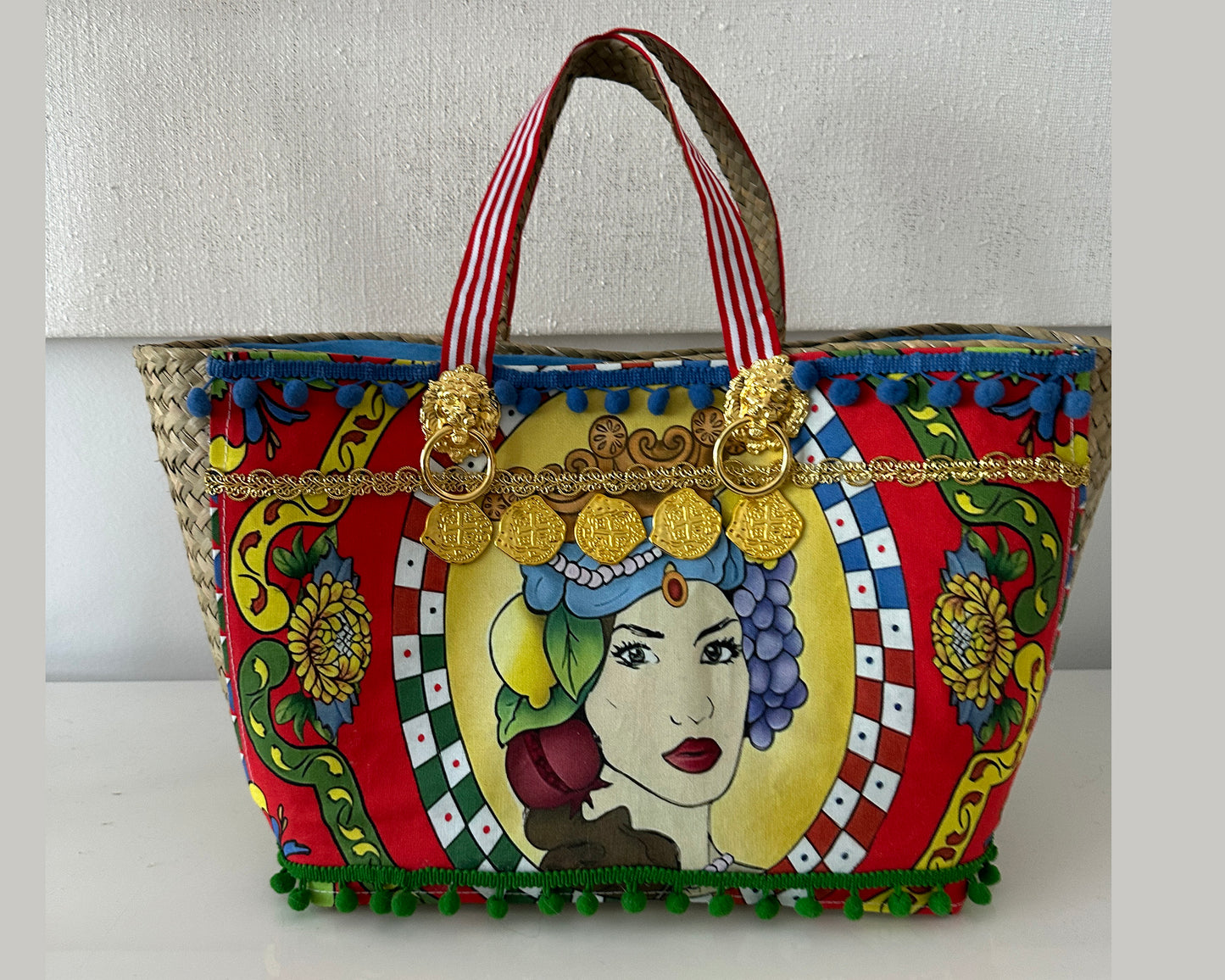 Multicolor tote with gold accents and pompoms.