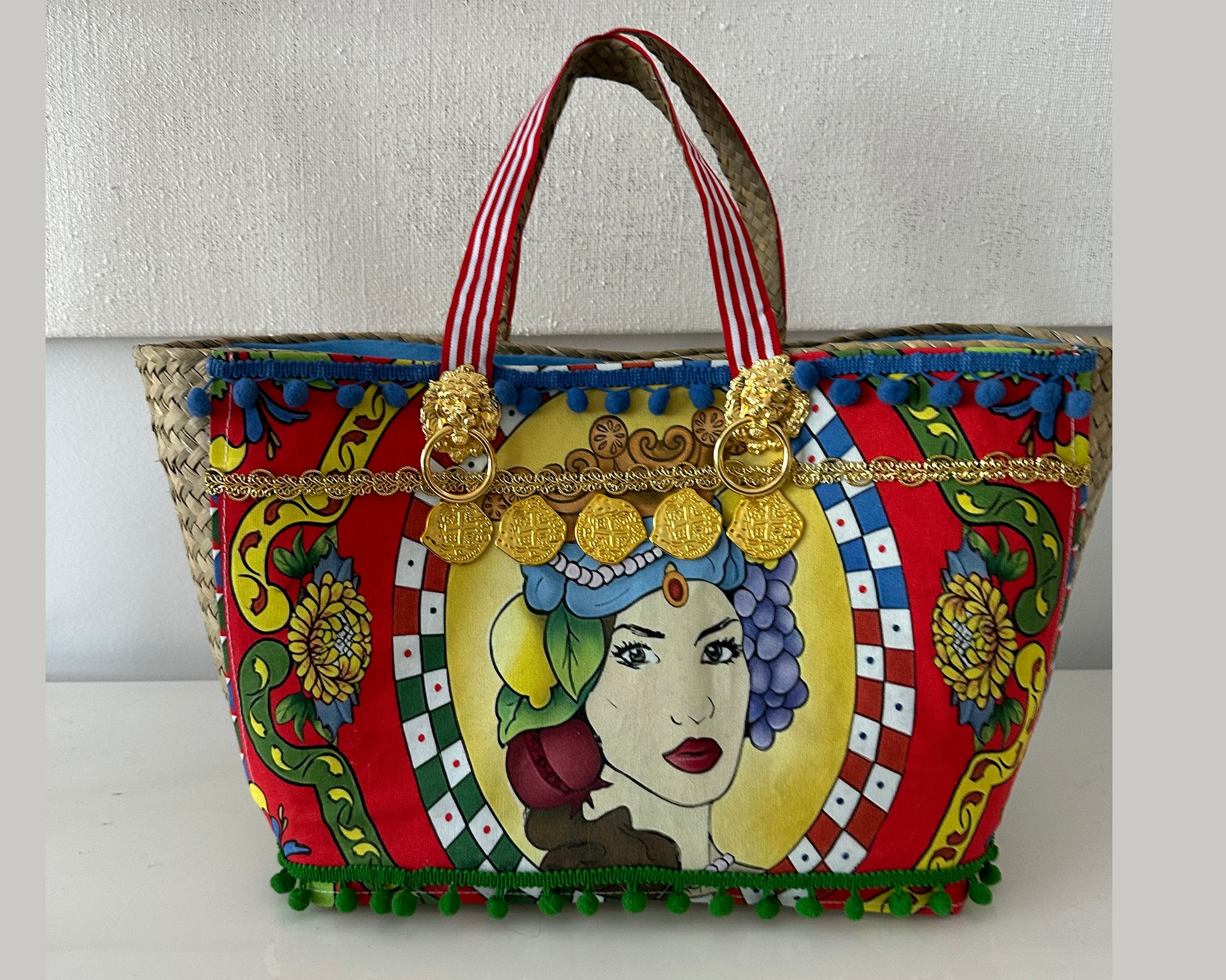 Multicolor tote with gold accents and pompoms.