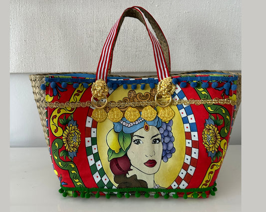 Multicolor tote with gold accents and pompoms.